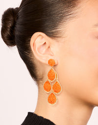 Showcasing orange paper teardrop earrings with statement styling and gold accents on ear view - link has visual effect only