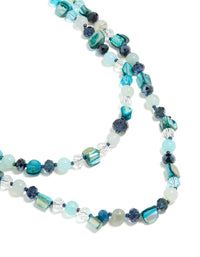 Showcasing an irregular double layered statement necklace with beads, ocean-inspired detailing in turquoise, navy, pale turquoise, and teal close up view - link has visual effect only
