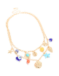 This evil eye and sea charm layered necklace showcases beads with ocean-inspired shell details and turquoise accents in gold front view - link has visual effect only