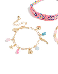 Showcasing gold pink beaded and sea charm bracelets in a 3-pack with ocean and tassel details crafted from cord close up view - link has visual effect only