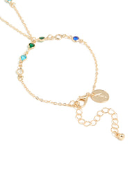 Highlighting the adjustable clasp detail of a statement hand chain in multicolor diamantes with green, red, and blue stones closure detail view - link has visual effect only