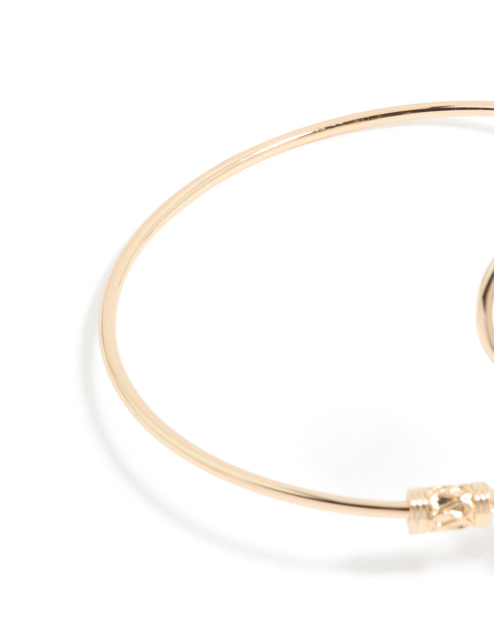 Designed with celestial sun detailing and a swirl design, this gold statement cuff is shown in closure detail view