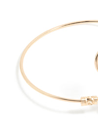 Designed with celestial sun detailing and a swirl design, this gold statement cuff is shown in closure detail view - link has visual effect only