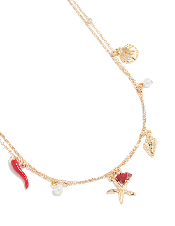 Crafted in gold, this ball and shell charm layered waist chain features pearl accents, embellished detailing, and an ocean-inspired design in detail view