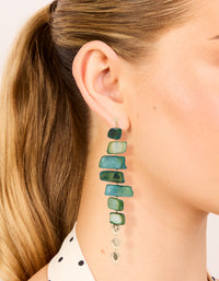 Showcasing dark green acrylic irregular shaped drop earrings featuring beads in teal and pale green with gold accents on ear view - link has visual effect only