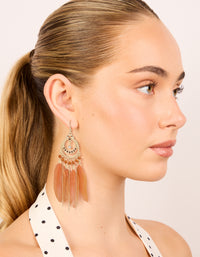 Designed with beads, feathers in coral and gold, these statement drop earrings presented in on model view - link has visual effect only