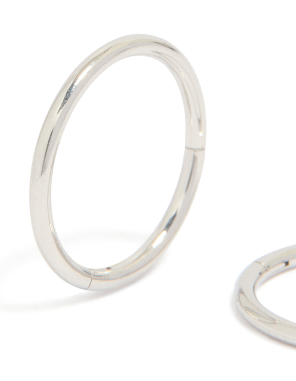 Displaying statement chunky surgical steel sleeper hoop earrings in silver close up view