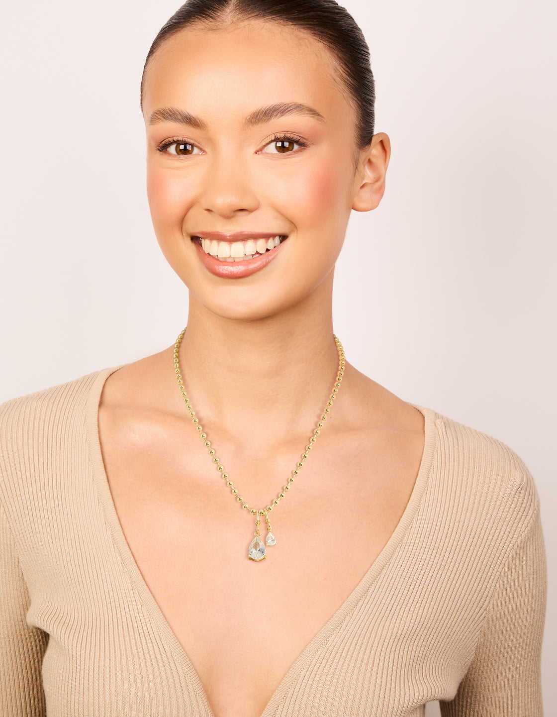 Elegantly styled gold plated double cubic zirconia teardrop pendant necklace on model view