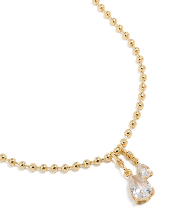 Showcasing double teardrop cubic zirconia pendant on gold plated ball chain necklace close up view