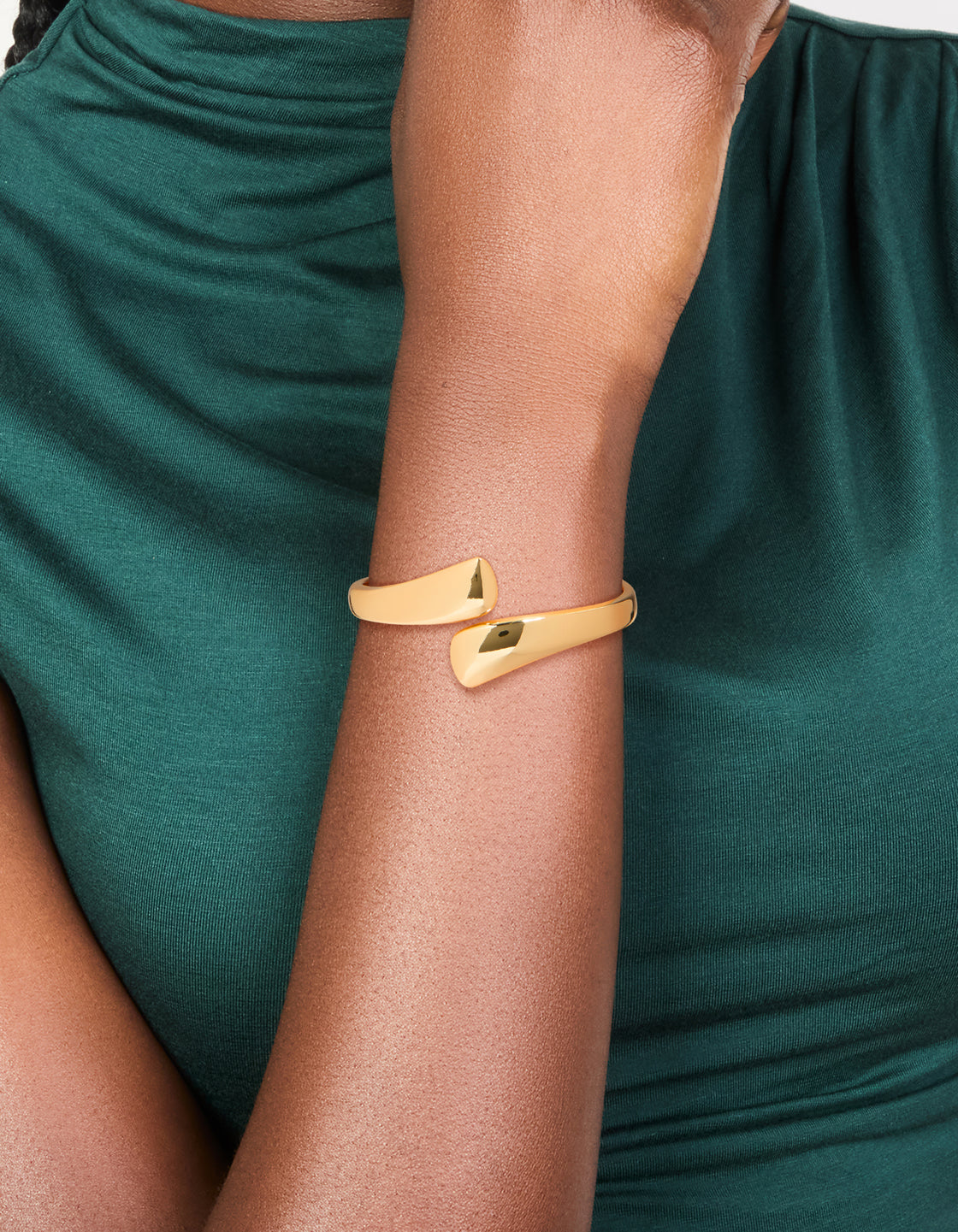 Stylish gold plated flat teardrop hinged bangle worn on wrist view