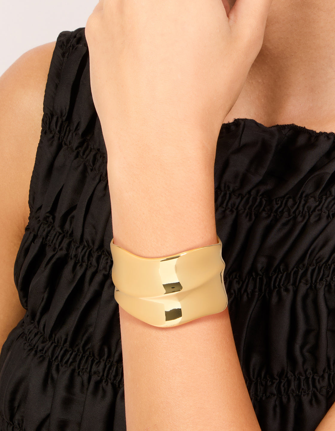 Featuring a gold plated wide organic wrist cuff in statement bangle style on wrist view