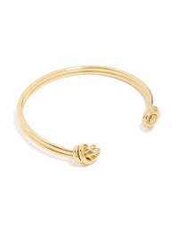 Showcasing a gold plated double knotted centre wrist cuff with statement styling front view - link has visual effect only
