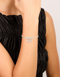 Crafted from silver plated materials, this dainty bow charm bracelet features cubic zirconia and heart accents on wrist view - link has visual effect only