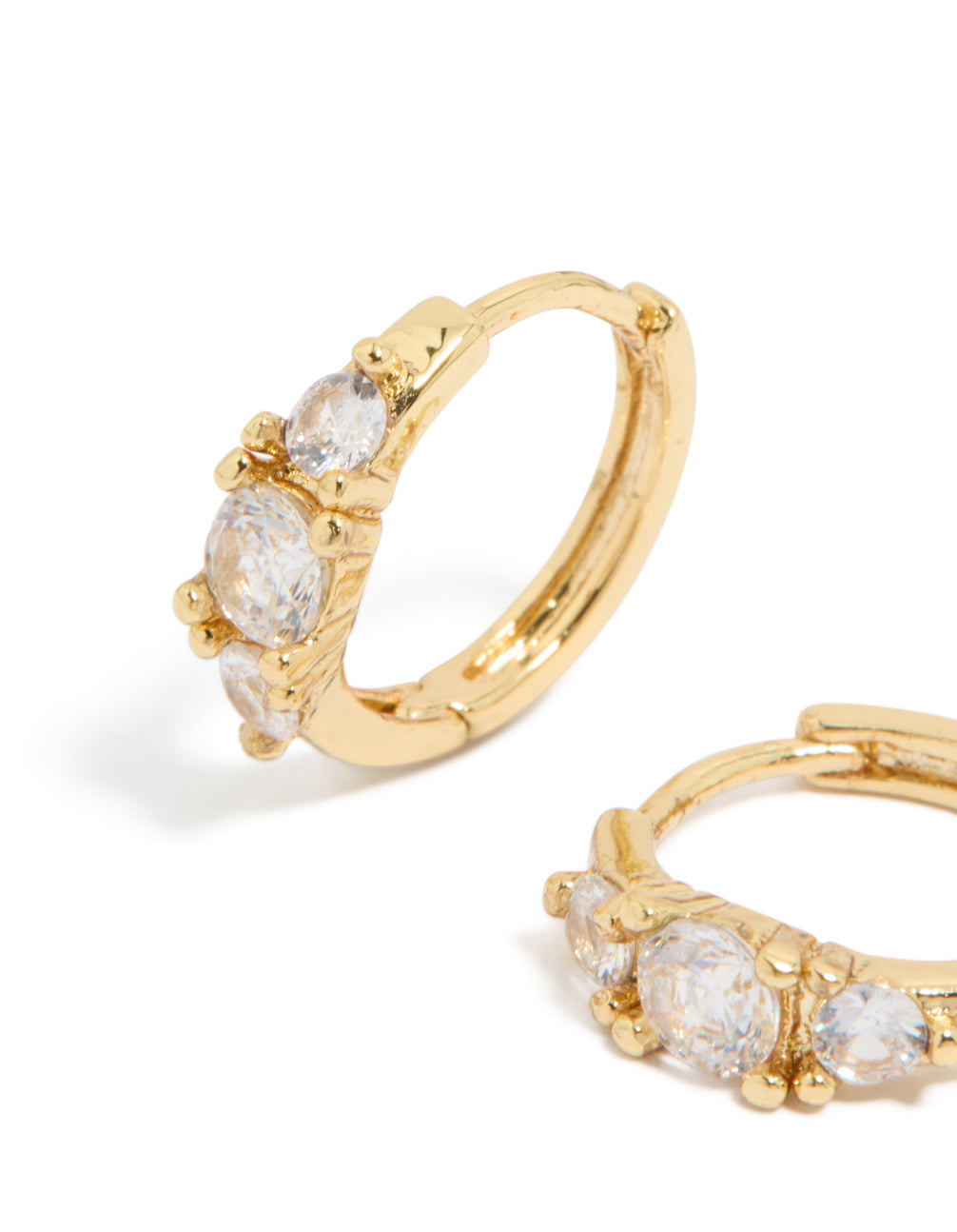 Designed with gold plated mixed sized cubic zirconia mini huggie earrings featuring huggie closure close up view