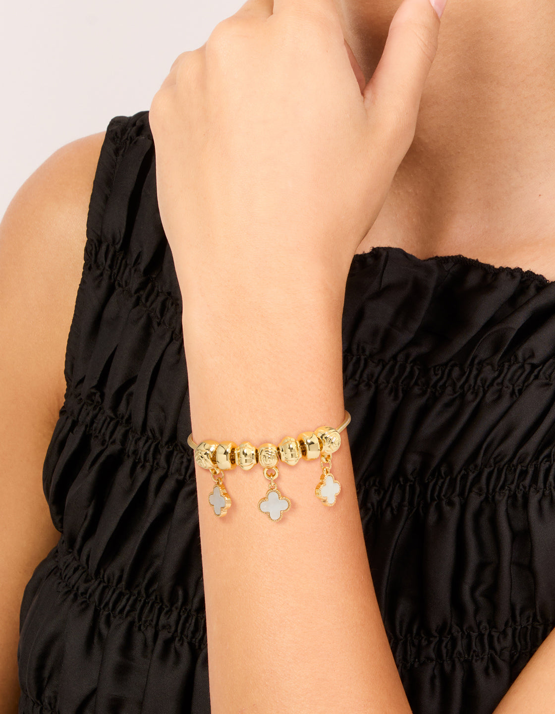 Elegant gold plated beaded charm toggle bracelet with pink genuine shell flower inlay on wrist view