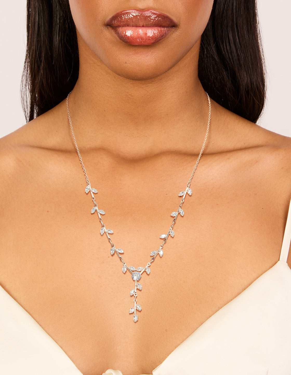 Crafted from rose gold plated cubic zirconia, this dainty vine spaced necklace with leaf details on neck view