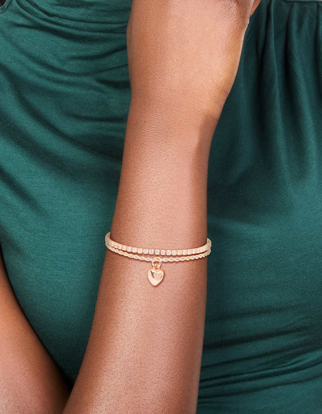 Designed with a rose gold plated cubic zirconia tennis and heart layered bracelet on wrist view