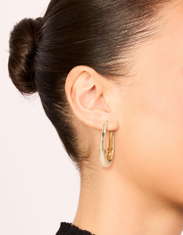 Showcasing gold plain wide hoop earrings in a polished finish on ear view