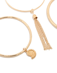 Detailed view of gold charm and tassel bangles in a 3-pack with shell and ocean-inspired details close up view - link has visual effect only