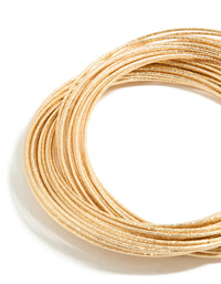 This multi crossover bangle features worn gold finish in close up view - link has visual effect only