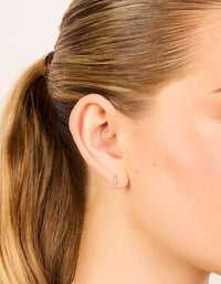 Showcasing dainty stud earrings crafted from gold plated sterling silver with cubic zirconia in a double bezel setting on ear view - link has visual effect only