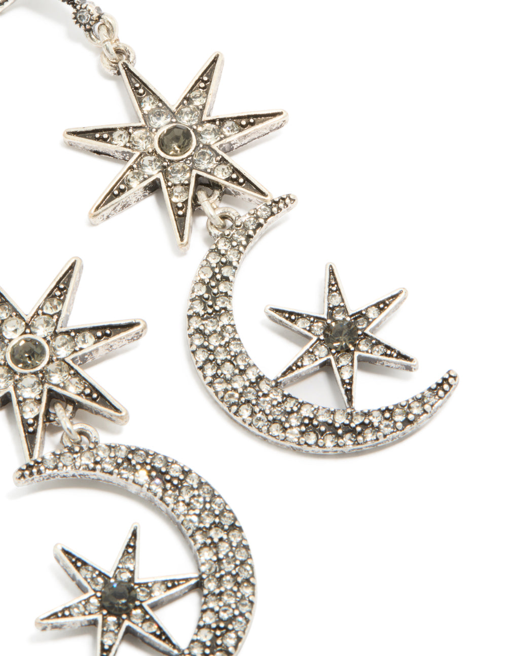 Highlighting the intricate craftsmanship of dainty celestial drop earrings with moon and star elements in silver post detail view