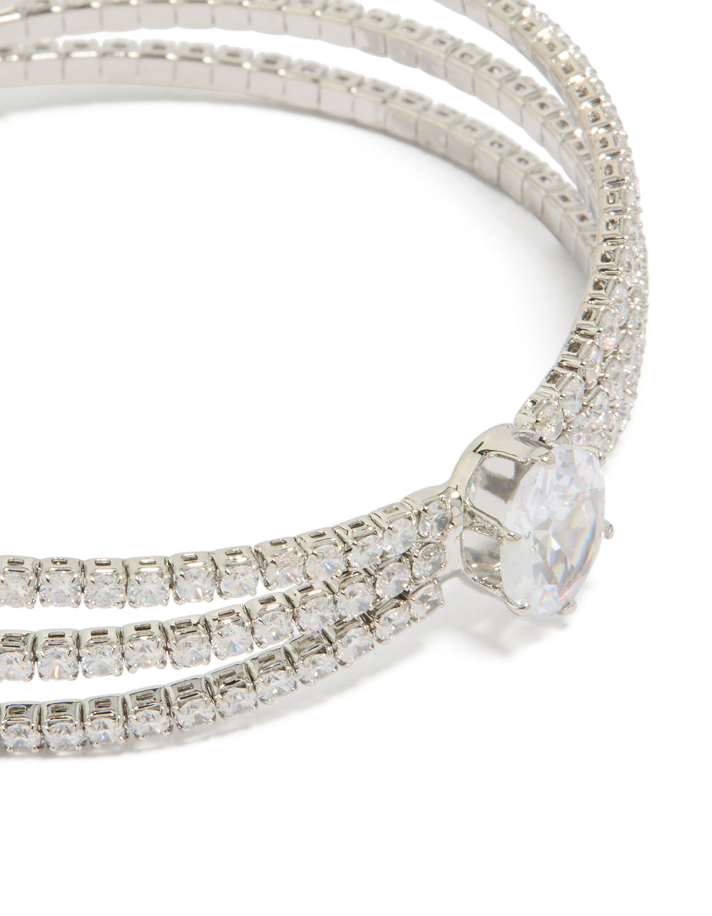 Highlighting a statement wrist cuff featuring cubic zirconia with oval stone cut in silver close up view