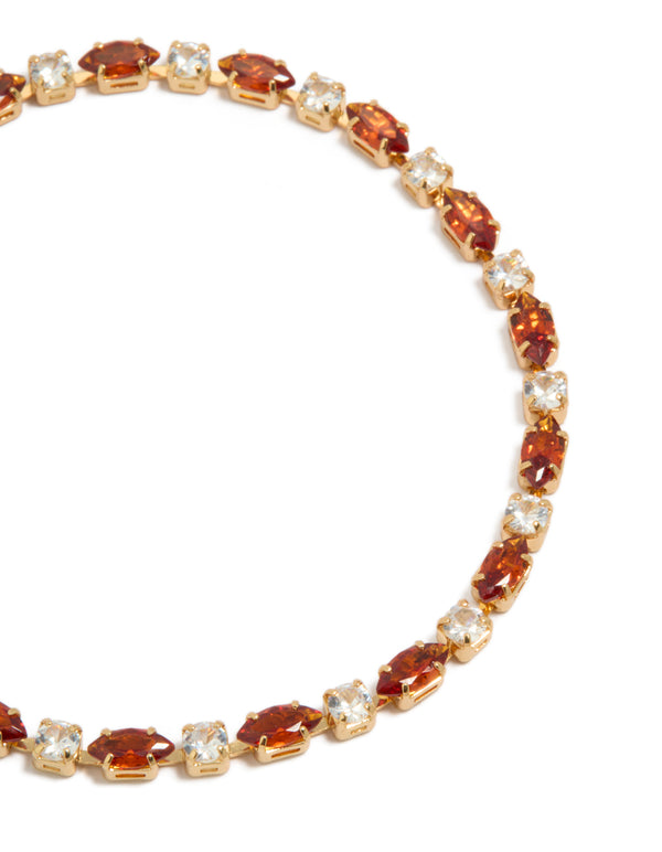 Highlighting a gold plated tennis bracelet featuring clear and cognac cubic zirconia in multi cut close up view