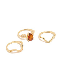 Showcasing statement wavy rings in a 3-pack featuring red teardrop cubic zirconia, crystal accents, and gold plated finish front view - link has visual effect only