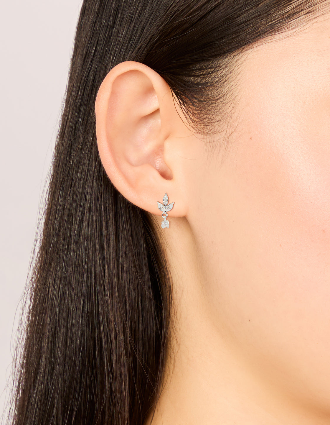 Waterproof stainless steel flower cubic zirconia flat back studs in dainty silver and clear stone on ear view