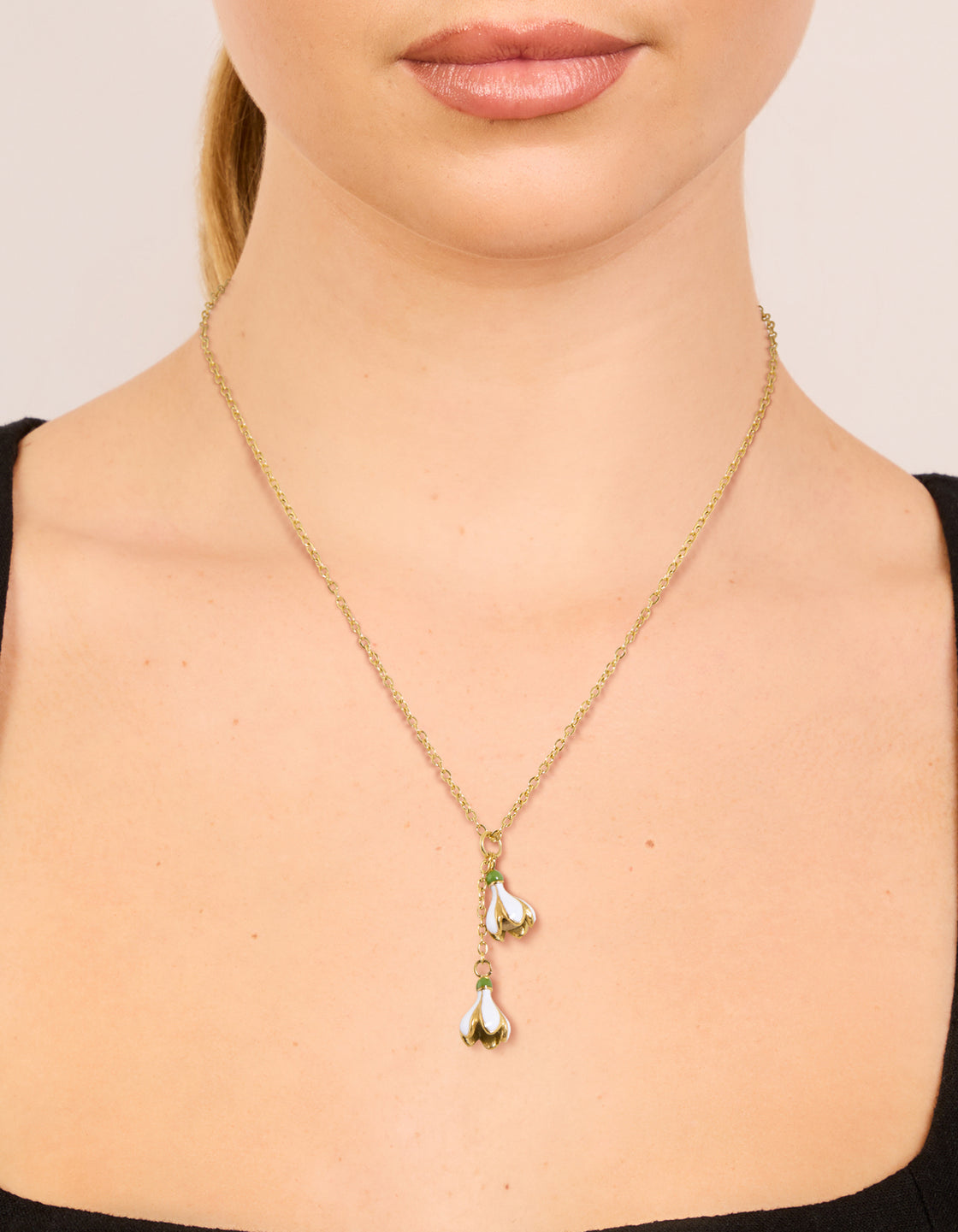 Featuring this floral pendant necklace in waterproof stainless steel with a plated finish and gold color on neck view