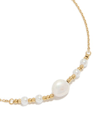 Showcasing a waterproof statement necklace crafted from stainless steel with beads and pearl accents in gold plated and white tones close up view - link has visual effect only