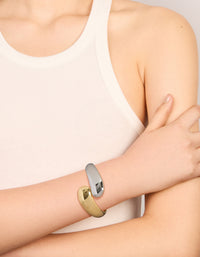 Featuring a waterproof mixed plated stainless steel round twisted cuff bangle in silver and gold with chunky styling on wrist view - link has visual effect only