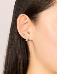 Showcasing gold plated mixed cut blue cubic zirconia mini earrings 3-pack with crystal and huggie closure on ear view - link has visual effect only