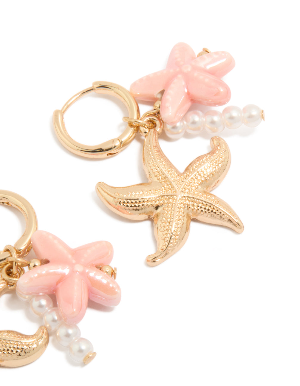 Explore dainty gold huggie earrings featuring pearl, pink flower, and starfish ocean theme charm drops in light pink and white post detail view