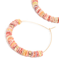 Featuring large hoop earrings with beaded genuine pink shells and statement style in gold close up view - link has visual effect only