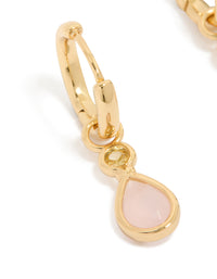 Elegant gold plated huggie earrings featuring pink cubic zirconia teardrop and statement design close up view - link has visual effect only