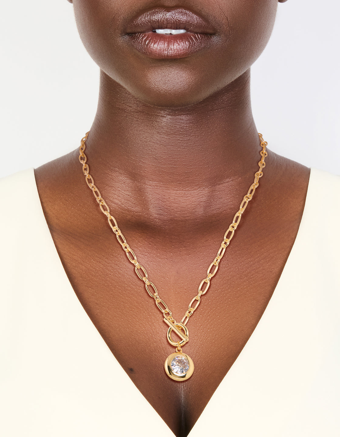 Discover this T-bar chain necklace featuring cubic zirconia and gold plated metal on neck view