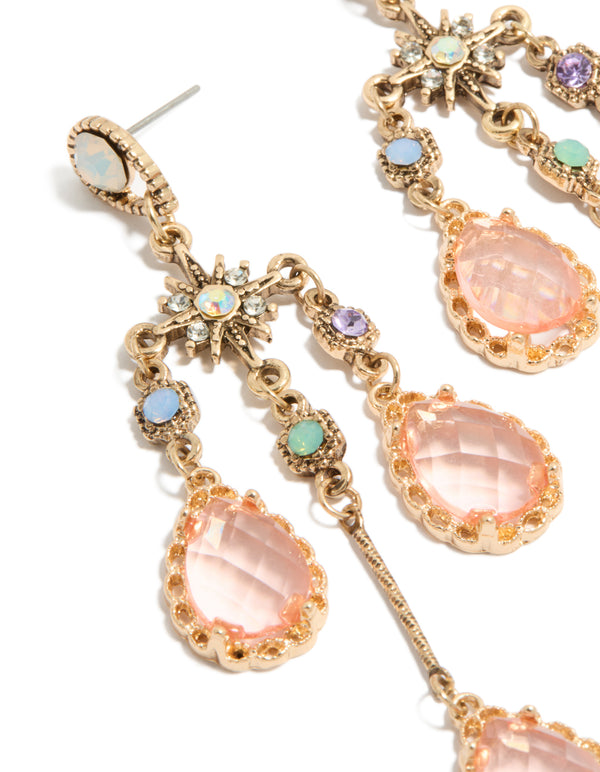 Crafted from gold with pink diamantes, these irregular long drop earrings showcase celestial charm details in close up view