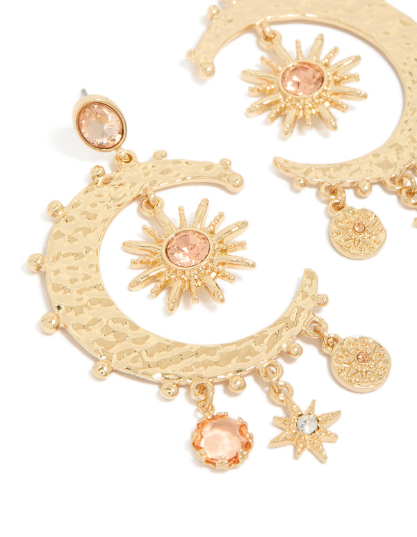 Featuring gold clear and pink diamante celestial moon drop earrings with charm and disc accents close up view
