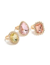 Showcasing a statement halo and oval stone cut diamante ring 3-pack in pink and purple pastel tones front view - link has visual effect only