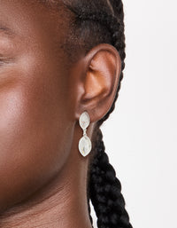 Featuring silver plated cubic zirconia double oval bezel drop earrings with clear stones in on ear view - link has visual effect only