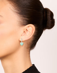 Showcasing silver plated pave blue heart drop hoop earrings with a hoop closure in pale turquoise on ear view - link has visual effect only
