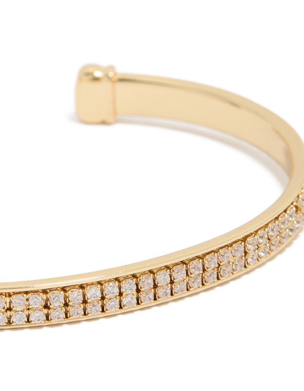 Elegant wrist cuff in gold plated finish with cubic zirconia flat bezel settings close up view