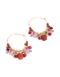 Showcase a pair of statement hoop earrings featuring beads and charms in gold, red, pink, and green tones front view - link has visual effect only