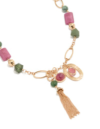 Showcasing a gold pink and green acrylic beaded long fringe necklace with charm tassel in statement style close up view - link has visual effect only