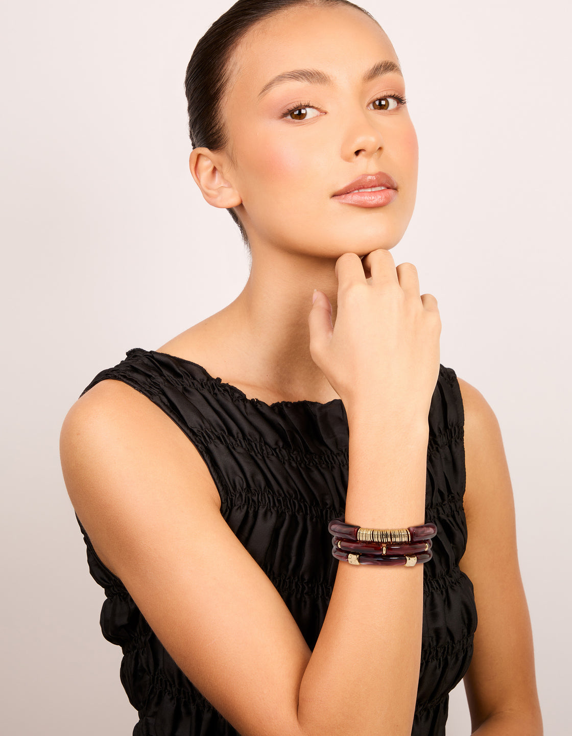 Displaying mixed burgundy resin and gold stretch bracelets with beads in a 3-pack on model view
