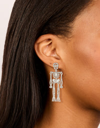 Showcasing statement drop earrings with glam skeleton design in diamante embellished silver on ear view - link has visual effect only
