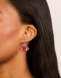 Featuring gold vampire kiss earrings with charm design in red and black on ear view - link has visual effect only