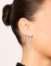 Featuring waterproof stainless steel extra thin hoop earrings in a statement 3-pack with silver finish on ear view - link has visual effect only